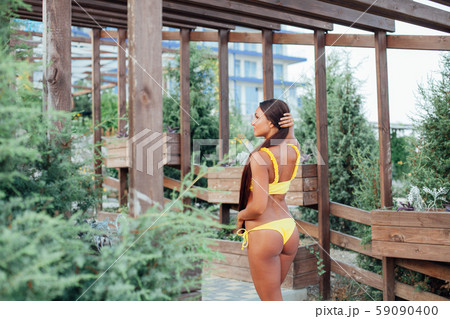 Beautiful woman with long hair in yellow swimsuit sunbathes on the beach 59090400