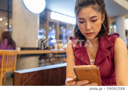 woman using smartphone in cafe 59091588