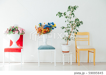 four chairs with flowers in the interior of a white empty room four chairs with flowers in the interior of a white empty room 59095645