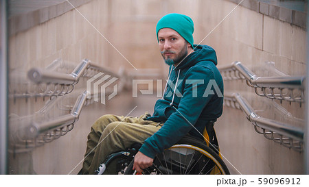 Disabled man in wheelchair on the beginning of the ramp - side view 59096912