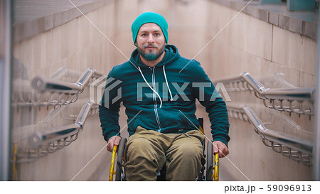 Disabled smiling man in wheelchair on the beginning of the ramp 59096913