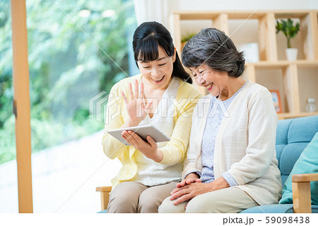 タブレット端末を操作する親子　母子　シニア女性　ミドル女性　2人 59098438