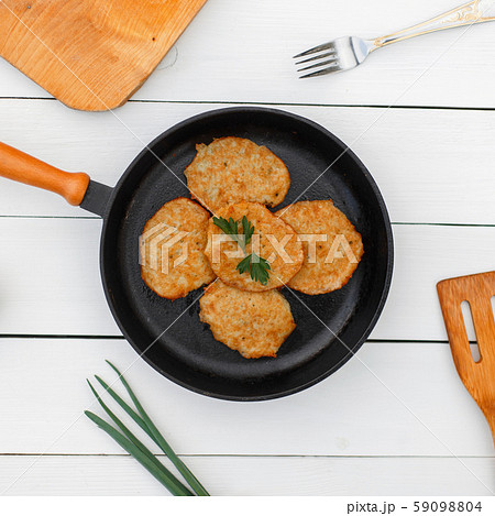 Delicious potato pancakes on a cast-iron frying pan Delicious potato pancakes on a cast-iron frying pan 59098804