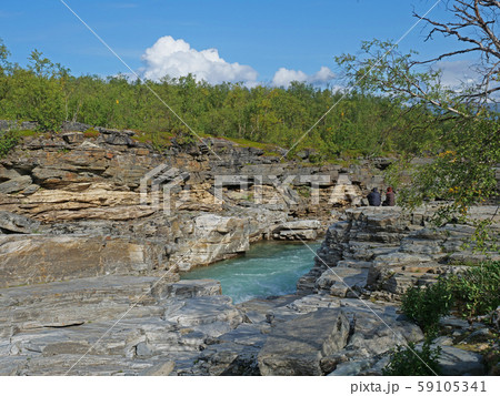 Two tourist couple sitting at blue glacial river 59105341