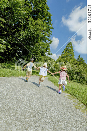 公園を走る子供たちの後ろ姿の写真素材