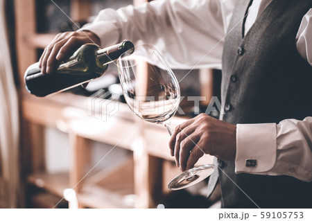 Sommelier Concept. Senior man standing pouring wine into glass close-up 59105753