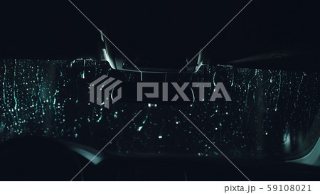 Drops flow down the windscreen. Inside view of a windshield car. Dark black cinematic picture 59108021