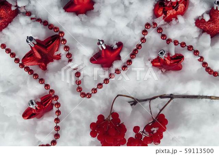 Red christmas toys and red berries on white snow 59113500