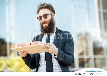 Businessman with pizza outdoors 59115299