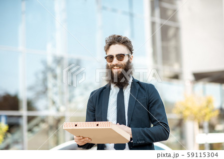 Businessman with pizza outdoors 59115304