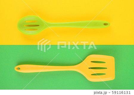 bright kitchen utensils on yellow and green background, creative idea 59116131