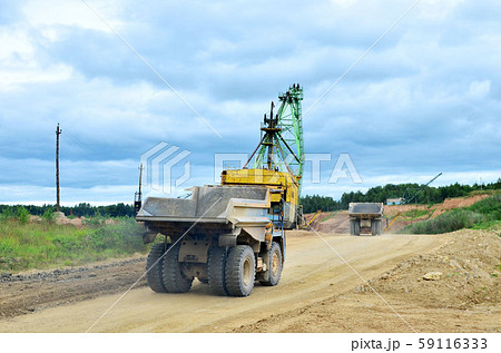 Big yellow dump truck working in the limestone open-pit. 59116333