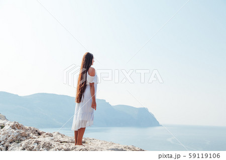 portrait of a beautiful woman with long hair in a dress on a cliff cliff by the sea portrait of a beautiful woman with long hair in a dress on a cliff cliff by the sea 59119106