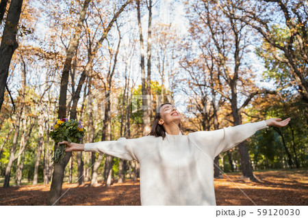 Cheerful woman loving autumn nature in the park Cheerful woman loving autumn nature in the park 59120030