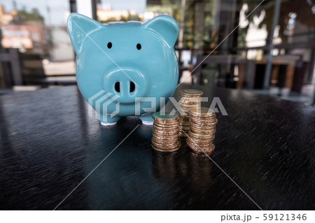 Blue piggy bank with coin pile, step up growing business to success and saving for retirement concept Blue piggy bank with coin pile, step up growing business to success and saving for retirement concept 59121346