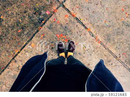 woman feet in black clothes stand with orange petals fall in raining day woman feet in black clothes stand with orange petals fall in raining day 59121683