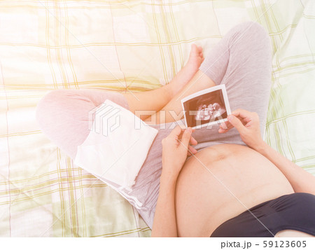 Close up Pregnant woman feeling happy love at home while looking of her Ultrasonography. 59123605