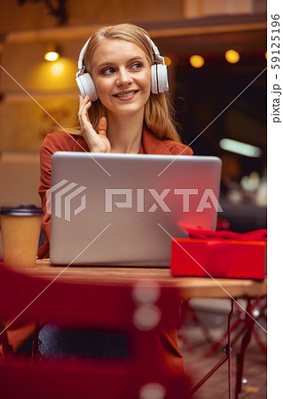Delighted girl listening to music at the table 59125196