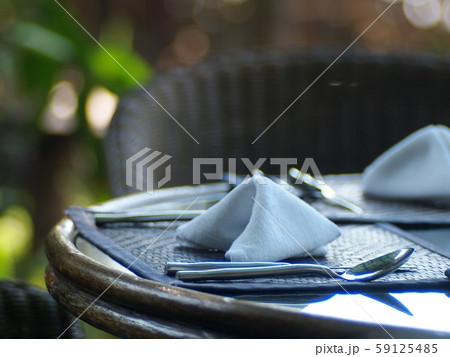 stainless steel silver colour fork & spoon on wooden table top with hand crafted decoration mat prepare for guest in vintage style garden restaurant under natural lighting warm welcome mood background stainless steel silver colour fork & spoon on wooden table top with hand crafted decoration mat prepare for guest in vintage style garden restaurant under natural lighting warm welcome mood background 59125485