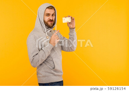 Attractive man in a gray hoodie points a finger at Attractive man in a gray hoodie points a finger at 59126154