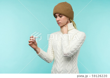 Young woman having flue taking thermometer against Young woman having flue taking thermometer against 59126220
