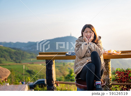 Asian women sit happily in the morning, sip coffee 59126519