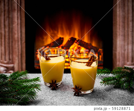 Two eggnog glasses at the fireplace 59128871