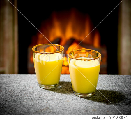 Two eggnog glasses at the fireplace Two eggnog glasses at the fireplace 59128874