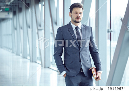 Portrait of a  young businessman in suit standing 59129674