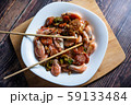 Cooked tasty dish fried shrimp with vegetables in sweet and sour sauce. Carrots, broccoli, cauliflower, shrimp are on a white plate. 59133484