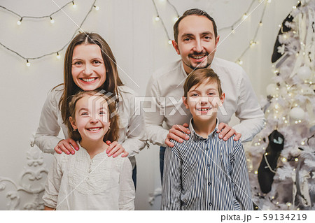 Portrait of happy family members: mother, father, son, daughter on white background near christmas Portrait of happy family members: mother, father, son, daughter on white background near christmas 59134219
