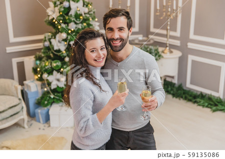 New Years Eve celebration photo with couple in love, drinking champagne over new year background. New Years Eve celebration photo with couple in love, drinking champagne over new year background. 59135086