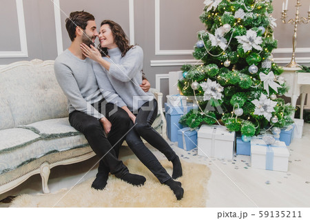 Danish hygge and homely environment concept. Up-view photo of lovely couple enjoying christmas time Danish hygge and homely environment concept. Up-view photo of lovely couple enjoying christmas time 59135211