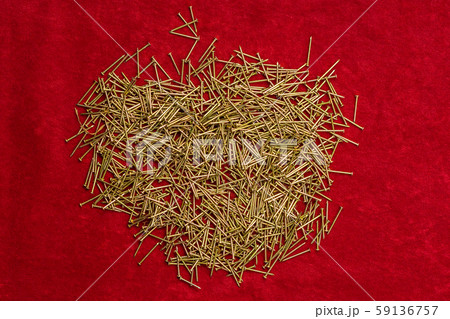 Pile of little nails on red background. Pile of little nails on red background. 59136757