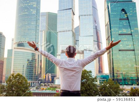 Back view of businessman looking on copy space while standing against glass skyscraper Back view of businessman looking on copy space while standing against glass skyscraper 59136851
