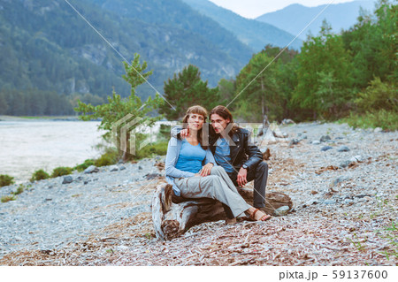 a couple of lovers sitting near the river 59137600