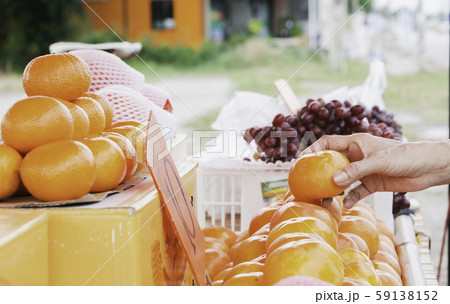 Young woman choosing orange at supermarket. Young woman choosing orange at supermarket. 59138152
