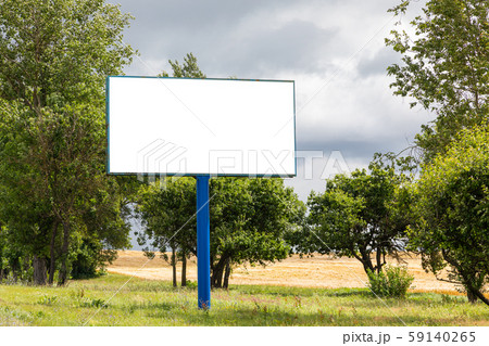 Big blank billboard mock-up along highway against meadow with trees 59140265