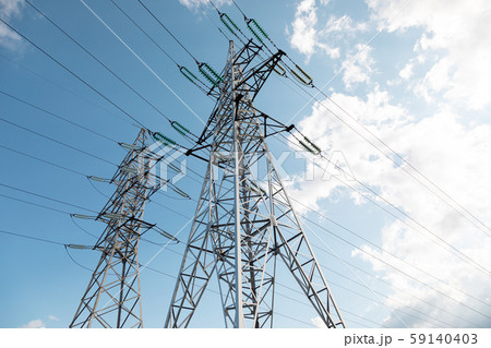 Bottom view of transmission towers against blue sky 59140403