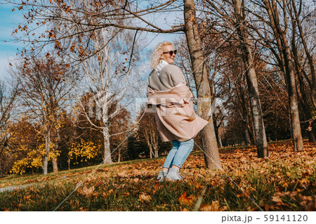 Beautiful woman in autumn park jumping and smiling Beautiful woman in autumn park jumping and smiling 59141120