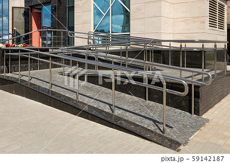 Wheelchair ramp of two uneven horizontal surfaces, street view, window with sky reflection Wheelchair ramp of two uneven horizontal surfaces, street view, window with sky reflection 59142187