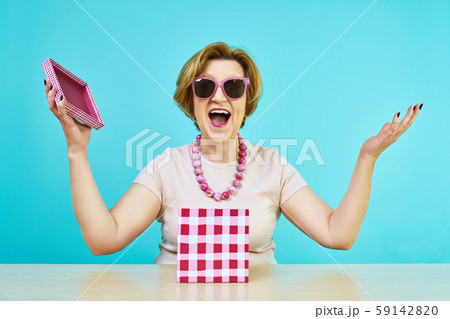 Funny excited old woman. A woman in age was very happy to receive gifts. holding opened present box Funny excited old woman. A woman in age was very happy to receive gifts. holding opened present box 59142820