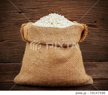 rice in burlap sack on wooden background rice in burlap sack on wooden background 59147496