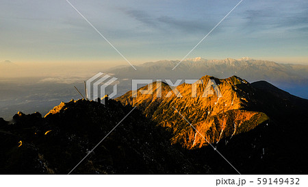 春の八ヶ岳登山：赤岳山頂の夜明け （手前に権現岳・奥に南アルプス） 59149432