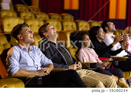 Male friends watching comedy movie in cinema 59160234