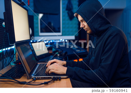 Hacker sitting at laptop, information hacking 59160941