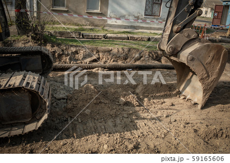 repair of a pipe, an excavator on the road repair of a pipe, an excavator on the road 59165606