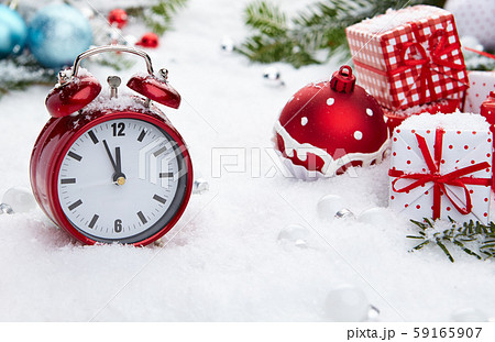 Red vintage alarm clock in the snow Red vintage alarm clock in the snow 59165907