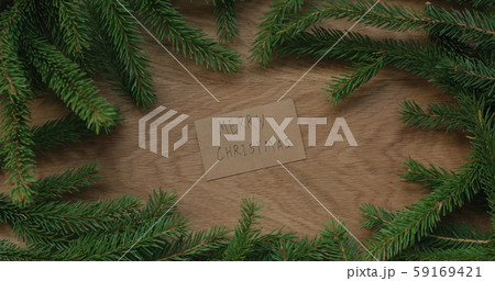 Top view merry christmas card on oak table decorated with spruce twigs Top view merry christmas card on oak table decorated with spruce twigs 59169421
