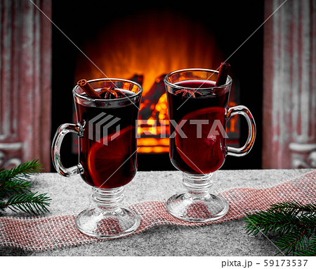Two mulled wine glasses by fireplace 59173537